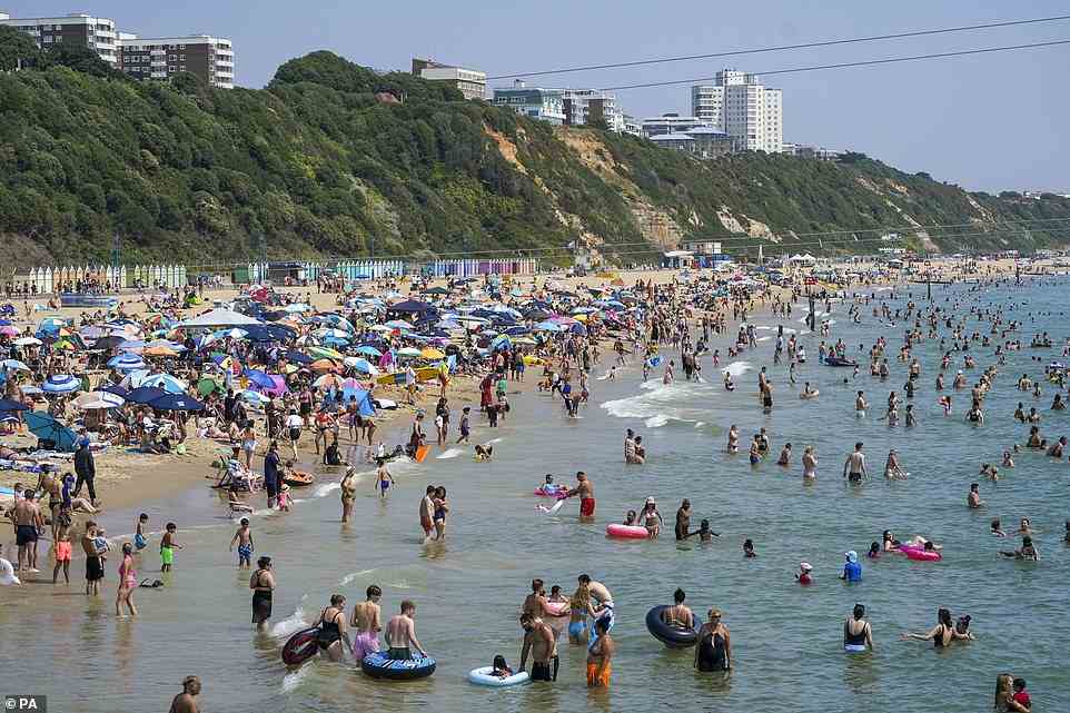 People on the beach in Bournemouth this afternoon as Britons bake on the hottest UK day on record