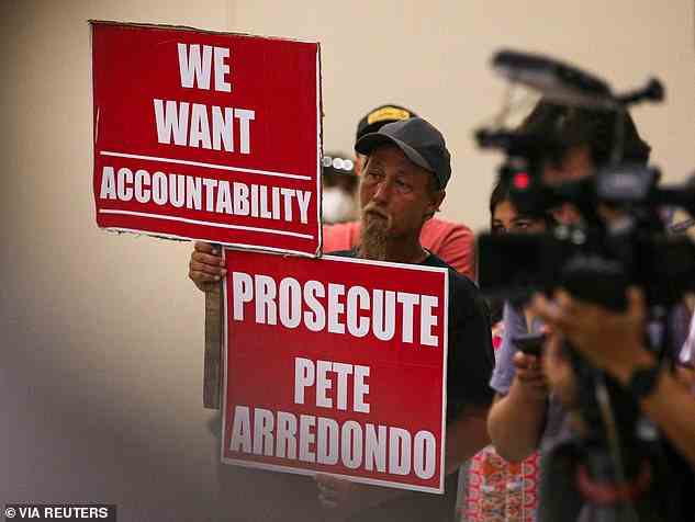 Community members and state police officials alike have sharply criticized the leadership of Arredondo. Michael Brown, an Uvalde community member who has a child that was enrolled at Robb Elementary, is seen holding signs calling for police accountability on Sunday