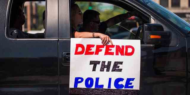 Demonstranten gehen während einer Aktion durch die Innenstadt von Bloomington, Indiana "Verteidige die Polizei" Veranstaltung.