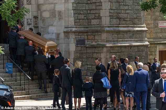 The family waits outside for the gold casket of Ivana Trump to be carried into the church on Wednesday