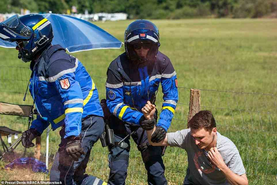 Activists who demonstrated on the road, and blocked the Tour de France are pictured being handcuffed by police on Saturday