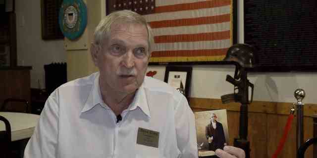Dave Giles, ein Kandidat in den republikanischen Vorwahlen für den 4. Bezirk von Arizona, winkt mit einer Taschenverfassung.