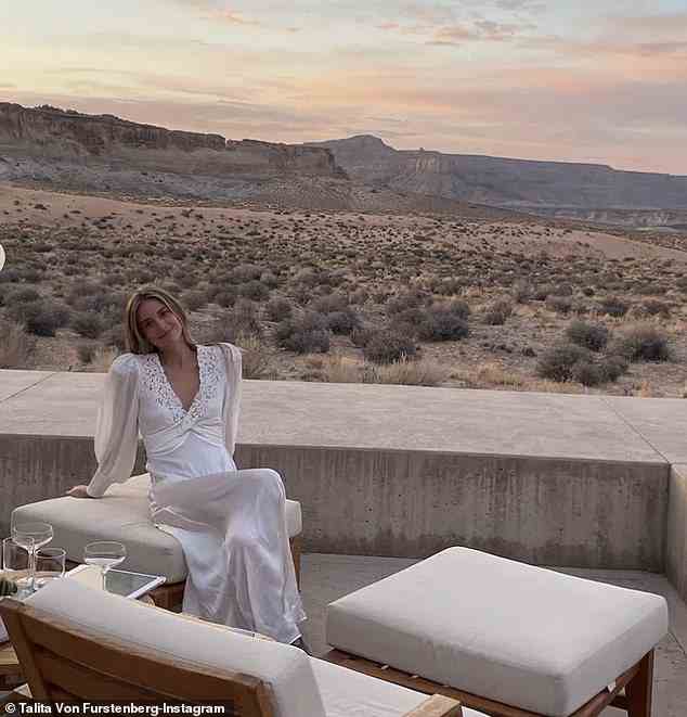 In einem anderen zog sie ein atemberaubendes weißes Satinkleid an, als sie vor einem Sonnenuntergang über einer Wüste posierte