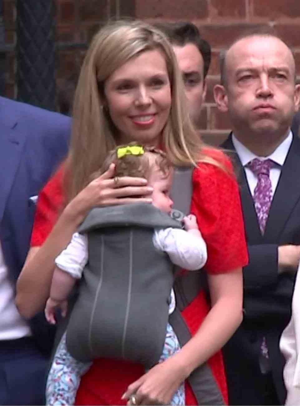 Carrie Johnson carried seven-month-old daughter Romy as she watched husband Boris Johnson deliver his resignation speech outside Downing Street today