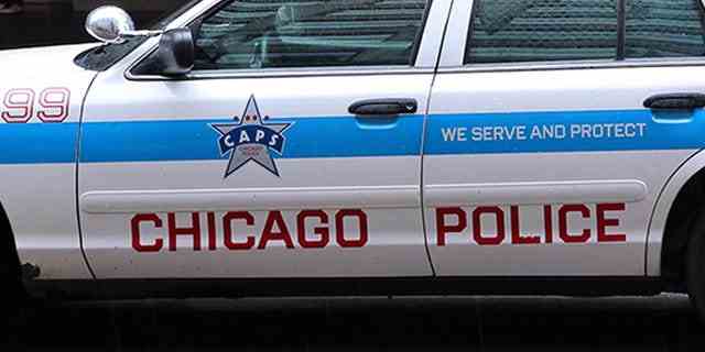Menschen gehen am 26. Juni 2013 in Chicago an einem Polizeiauto vorbei.