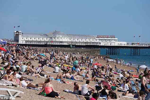 Da Großbritannien an diesem Wochenende heißer als die Karibik ist, sagen Wissenschaftler, dass es an der Zeit ist, die Auswirkungen von Hitze auf unser Gehirn ernster zu nehmen.  (Oben, Menschen am Strand von Brighton in East Sussex am Freitag)