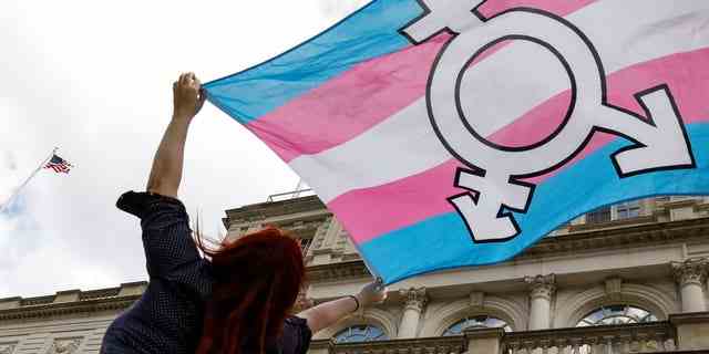 Eine Person hält während einer Kundgebung in New York City eine Transgender-Flagge hoch.