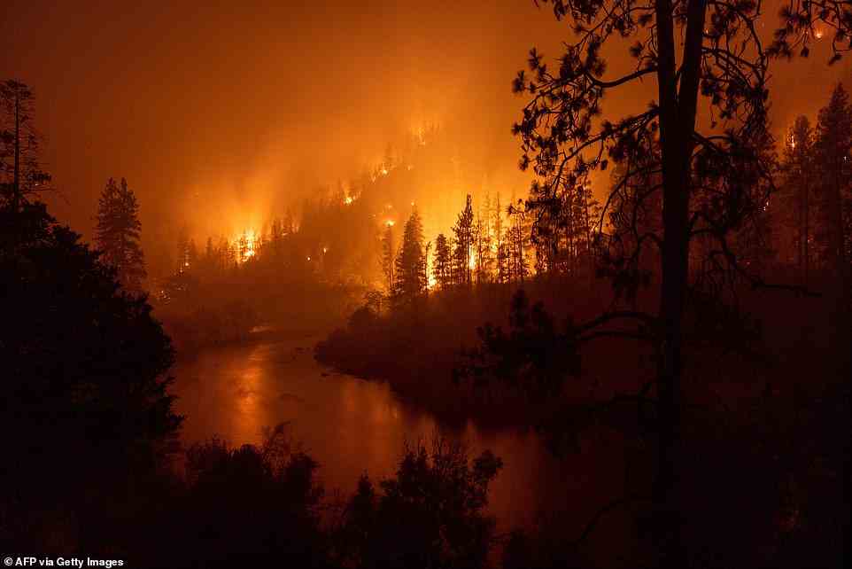 Flames burn to the Klamath River during the McKinney Fire in the Klamath National Forest northwest of Yreka, California, on July 31, 2022. The largest fire in California this year is forcing thousands of people to evacuate as it destroys homes and rips through the state's dry terrain