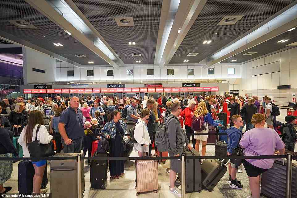 Passagiere stehen für den Check-in am Terminal 2 des Flughafens Manchester für Flüge am Samstag an, wenn sie in die Sommerferien gehen