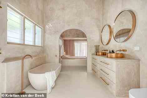 Das luxuriöse Badezimmer verfügt über goldene Waschbecken, Wasserhähne und Spiegel, eine riesige freistehende Badewanne und eine offene Dusche