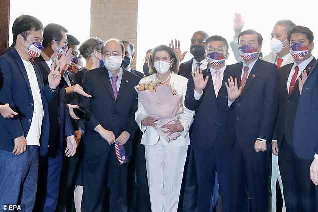 Nancy Pelosi hält einen Blumenstrauß in der Hand, der ihr scheinbar von taiwanesischen Gesetzgebern geschenkt wurde