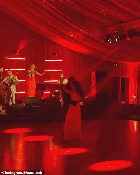 Die Frischvermählten hatten ihren ersten Tanz unter einem romantischen Rotlicht, als eine fünfköpfige Band für sie spielte