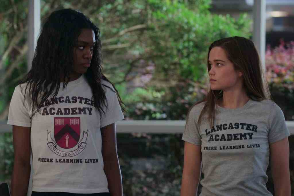   Imani Lewis als Calliope und Sarah Catherine Hook als Juliette sehen sich in First Kill in T-Shirts der Lancaster Academy an 
