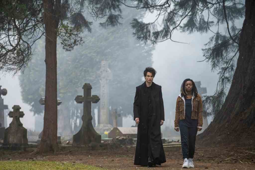 Tom Sturridge als Dream und Vanesu Samunyai als Rose Walker, die in The Sandman durch einen Friedhof gehen