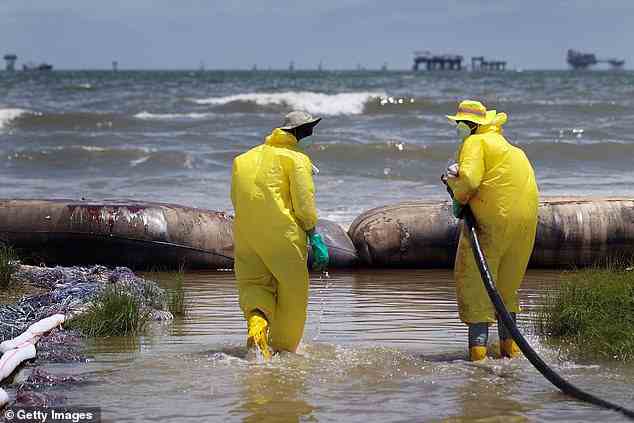 Arbeiter werden gesehen, wie sie am 28. Juni 2010 in Port Fourchon, Louisiana, mit einem Vakuumschlauch einen Teil des Öls auffangen, das von der Deepwater Horizon-Ölpest im Golf von Mexiko nach Fourchon Beach gespült wird