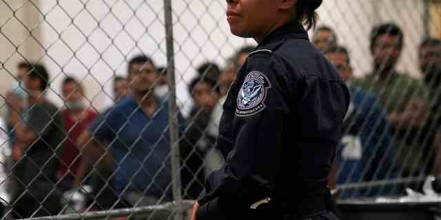 Ein US-Zoll- und Grenzschutzbeamter überwacht am 12. Juli 2019 alleinstehende männliche Häftlinge an der Grenzschutzstation in McAllen, Texas, USA.  