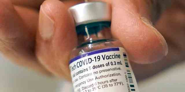 Dr. Manjul Shukla überträgt am Donnerstag, den 2. Dezember 2021, in einer mobilen Impfklinik in Worcester, Mass., den COVID-19-Impfstoff von Pfizer in eine Spritze.