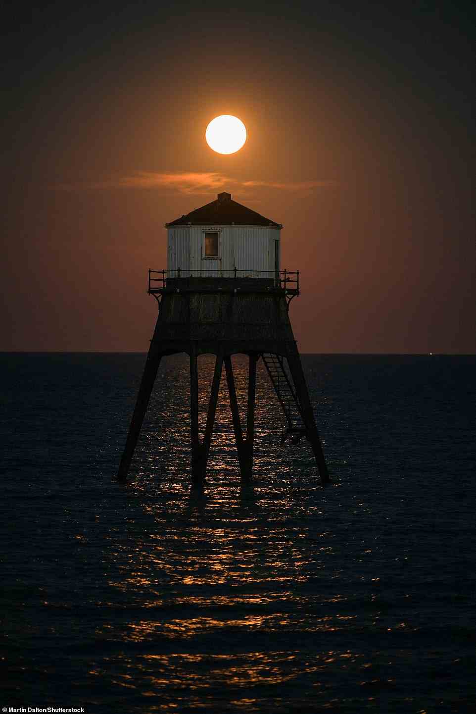 The bright moon illuminates the waters off the English coast tonight. Pictured in the foreground is Dovercourt Lower Lighthouse in Essex