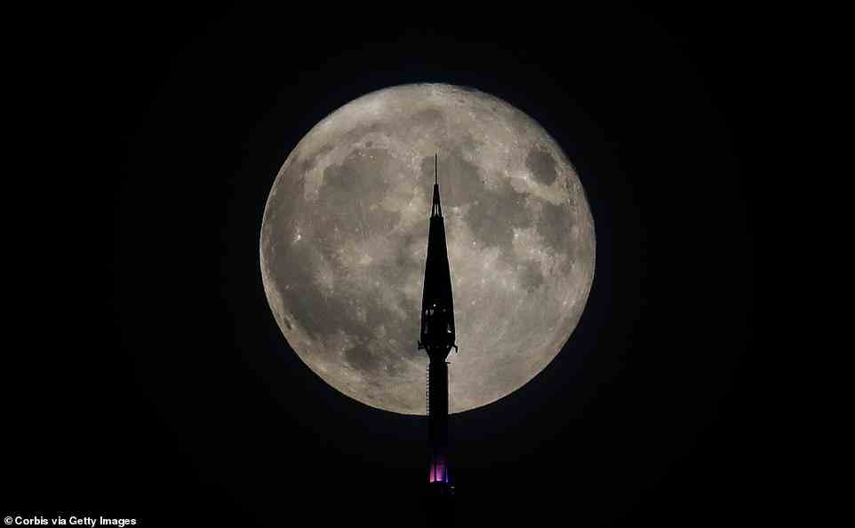 July's supermoon rises behind the antenna on top of One World Trade Center in New York City on July 13, 2022