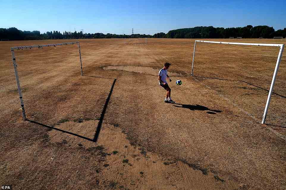 A general view of dry grass on the football pitches at Hackney Marshes. The Met Office has issued an amber extreme heat warning which came into force on Thursday and covers the rest of this week