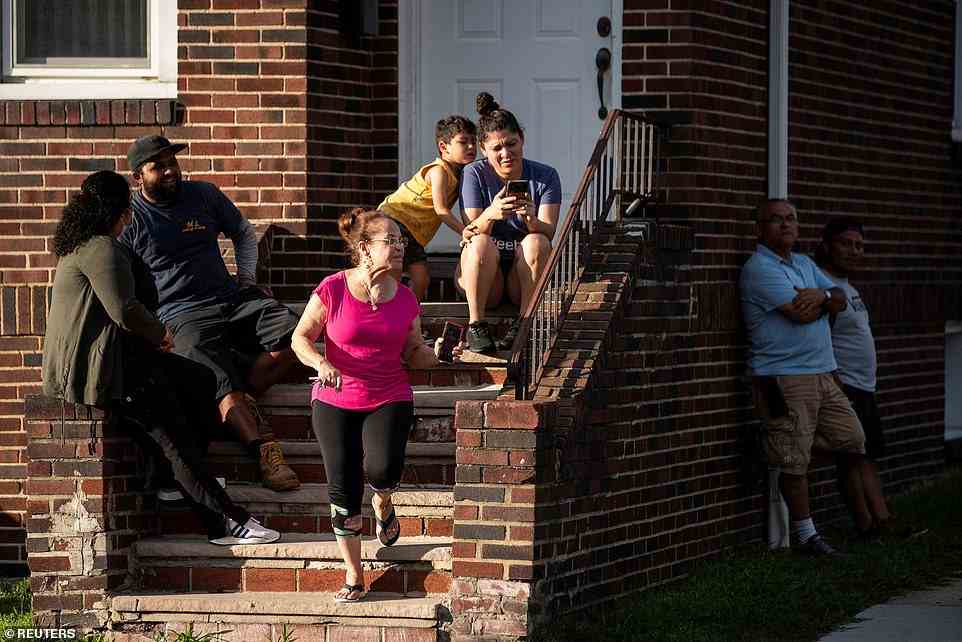 Residents look on as New Jersey Police officers search the building where Matar, lives in Fairview, New Jersey