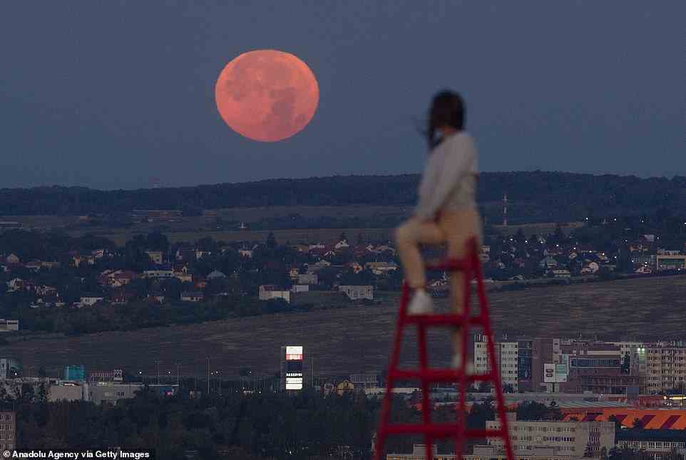 A person turns to watch the last supermoon of the year in the early morning hours above Kosice, Slovakia on Friday, August 12