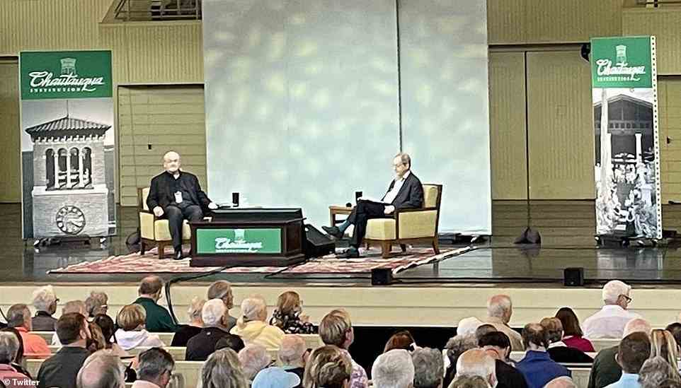 On stage at the lecture theatre: Sir Salman Rushdie is seen on the left at the the Chautauqua Institution