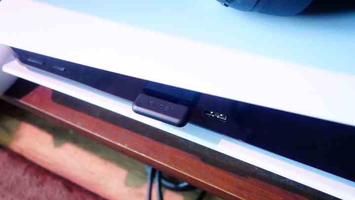 Ein Razer Barracuda Pro USB-C-Dongle, der an eine PS5 angeschlossen ist.