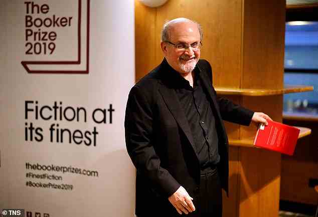 Autor Salman Rushdie lächelt, als er mit seinem Buch an einem Fototermin teilnimmt "Quichotte" für die Autoren, die für den Booker Prize for Fiction 2019 im Southbank Centre in London in die engere Wahl gekommen sind