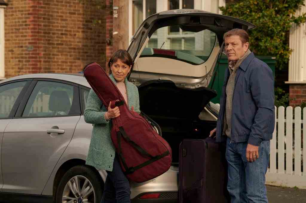,Ian (SEAN BEAN) und Emma (NICOLA WALKER) holen in Marriage eine Gitarre aus dem Kofferraum eines Autos