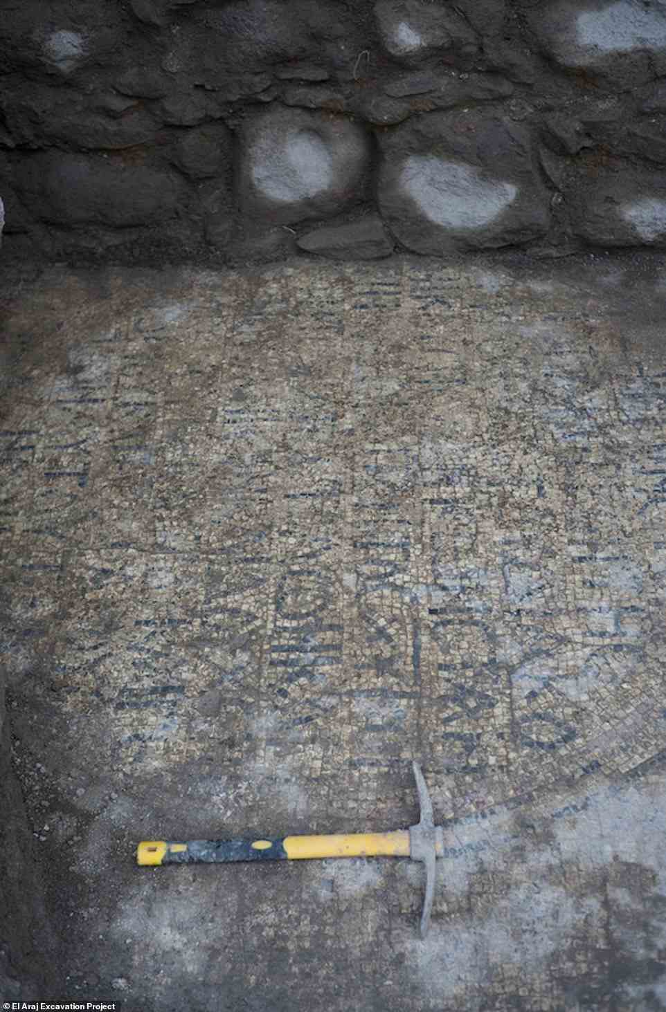 Die Inschrift ist Teil eines größeren Mosaikbodens im Diakonion (Sakristei) der Kirche, der teilweise mit floralen Mustern verziert und von einem runden Medaillon aus zwei Reihen schwarzer Steinchen eingerahmt ist