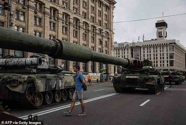 Ein Mann sieht sich heute früh zerstörte russische Panzerfahrzeuge in der Chreschtschatyk-Straße an