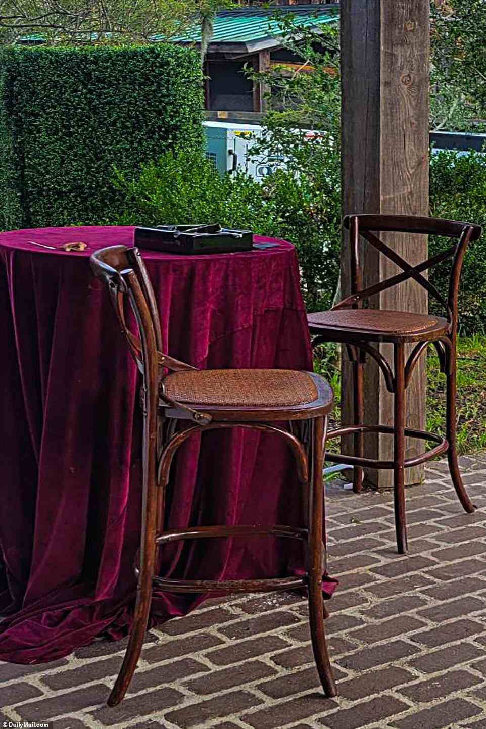 BILD: Rubinrote Tischdecken aus Samt baumelten an hohen Tischen, wo die Gäste nach der Zeremonie Cocktails an einer Holzbar und Zigarren genossen