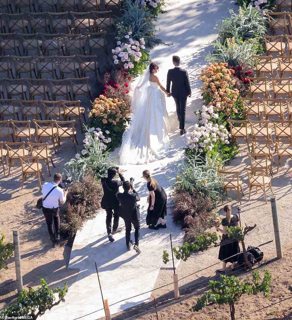 A group of photographers snapped the famed couple from behind as they made their way to the altar