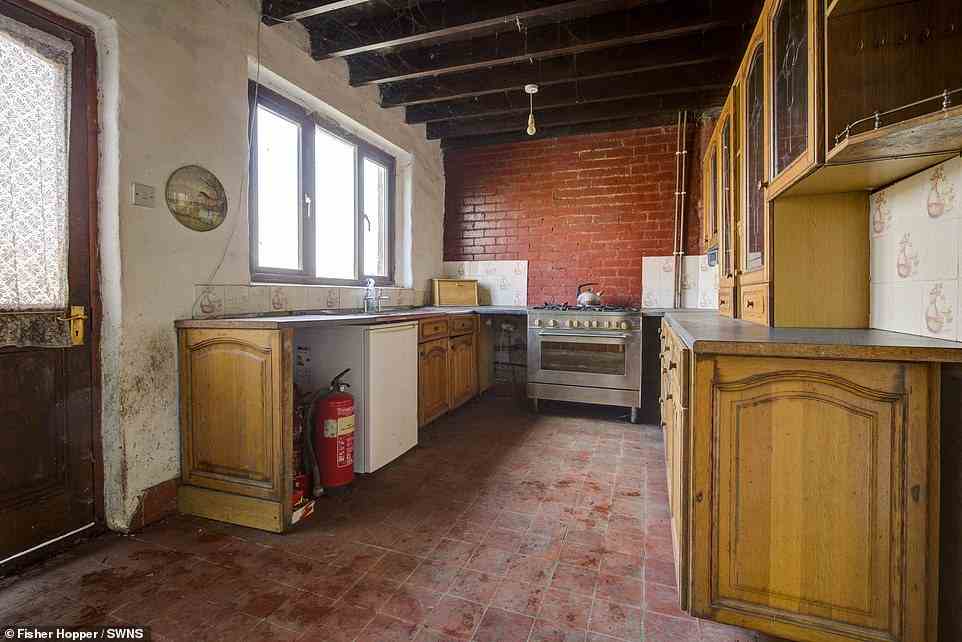 Inzwischen muss auch die Küche modernisiert werden, da sie alte hölzerne Schranktüren, unverputzte rote Backsteinwände und dunkle Holzbalkendecken aufweist