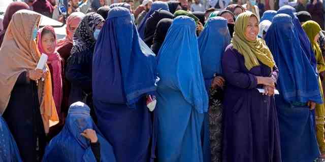 Afghanische Frauen warten im April 2022 in Kabul, Afghanistan, auf Lebensmittel, die von einer humanitären Hilfsgruppe verteilt werden. 