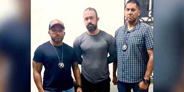 Marshals flankieren RJ McLeod nach seiner Festnahme in Sonsonate, El Salvador, am Montag, den 29. August 2022.
