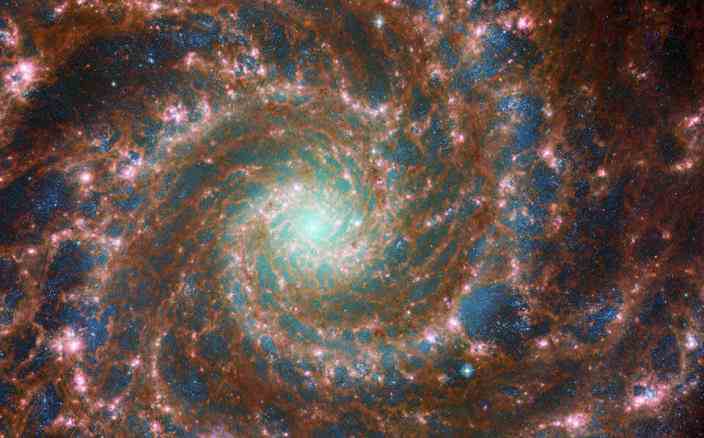 Auf diesem kombinierten Bild aus optischem und mittlerem Infrarot erstrahlt M74 am hellsten und enthält Daten sowohl des NASA/ESA-Weltraumteleskops Hubble als auch des NASA/ESA/CSA-Weltraumteleskops James Webb.   / Kredit: Europäische Weltraumorganisation