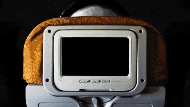 Animiertes GIF eines Bildschirms auf einem Flugzeugsitz, auf dem Filmausschnitte abgespielt werden