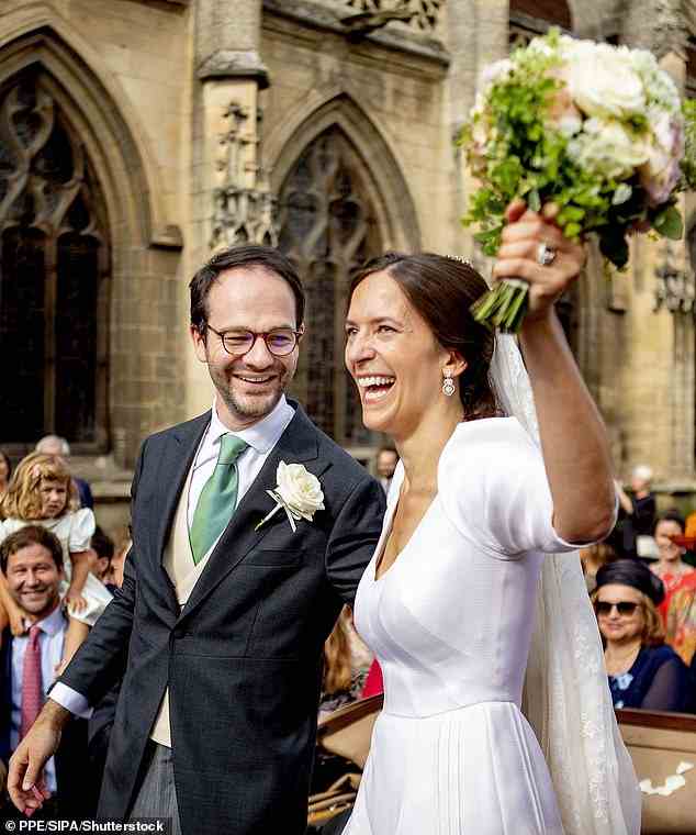 Nach der Zeremonie schwenkte die strahlende Braut fröhlich ihren Blumenstrauß in die Luft, als sie mit ihrem Mann aus der Kirche trat