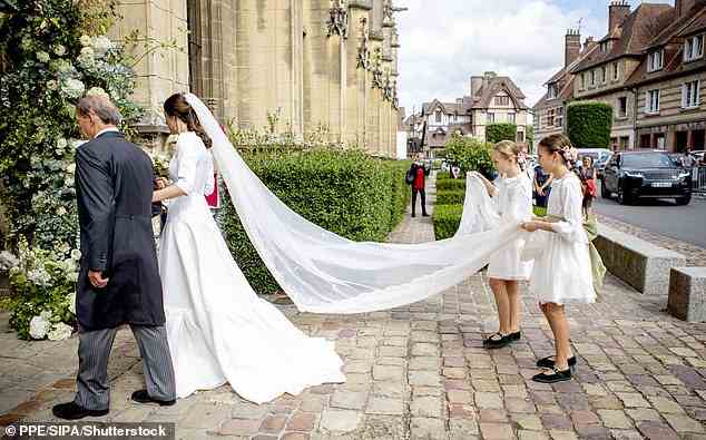 Zwei Brautjungfern wurden mit der wichtigen Rolle beauftragt, den Schleier der Braut zu tragen, als sie begann, den Gang entlang zu gehen