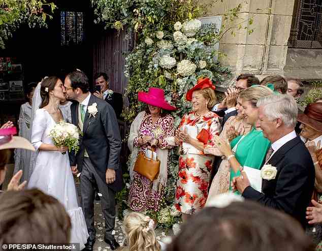Das glückliche Paar tauschte einen Kuss aus, während die Gäste Blumenblätter auf sie warfen, um ihre Vereinigung zu feiern