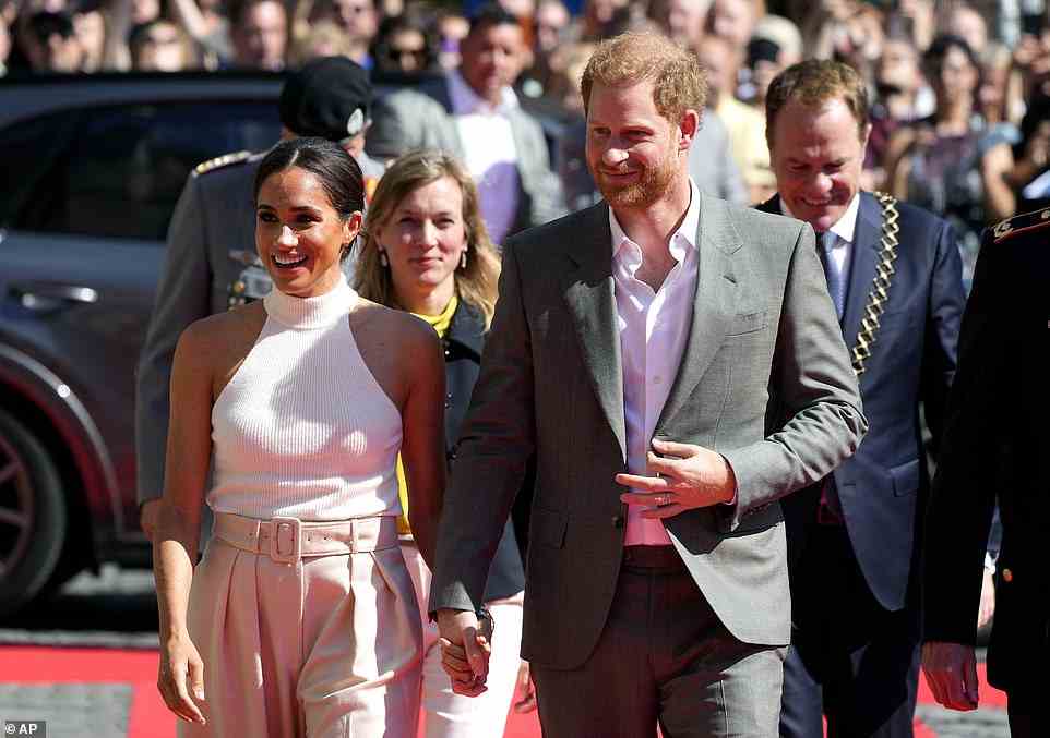Meghan and Harry looked like the perfect pairing as they walked hand-in-hand as they arrived at City Hall, with Harry looking dapper in a dark grey suit and white shirt