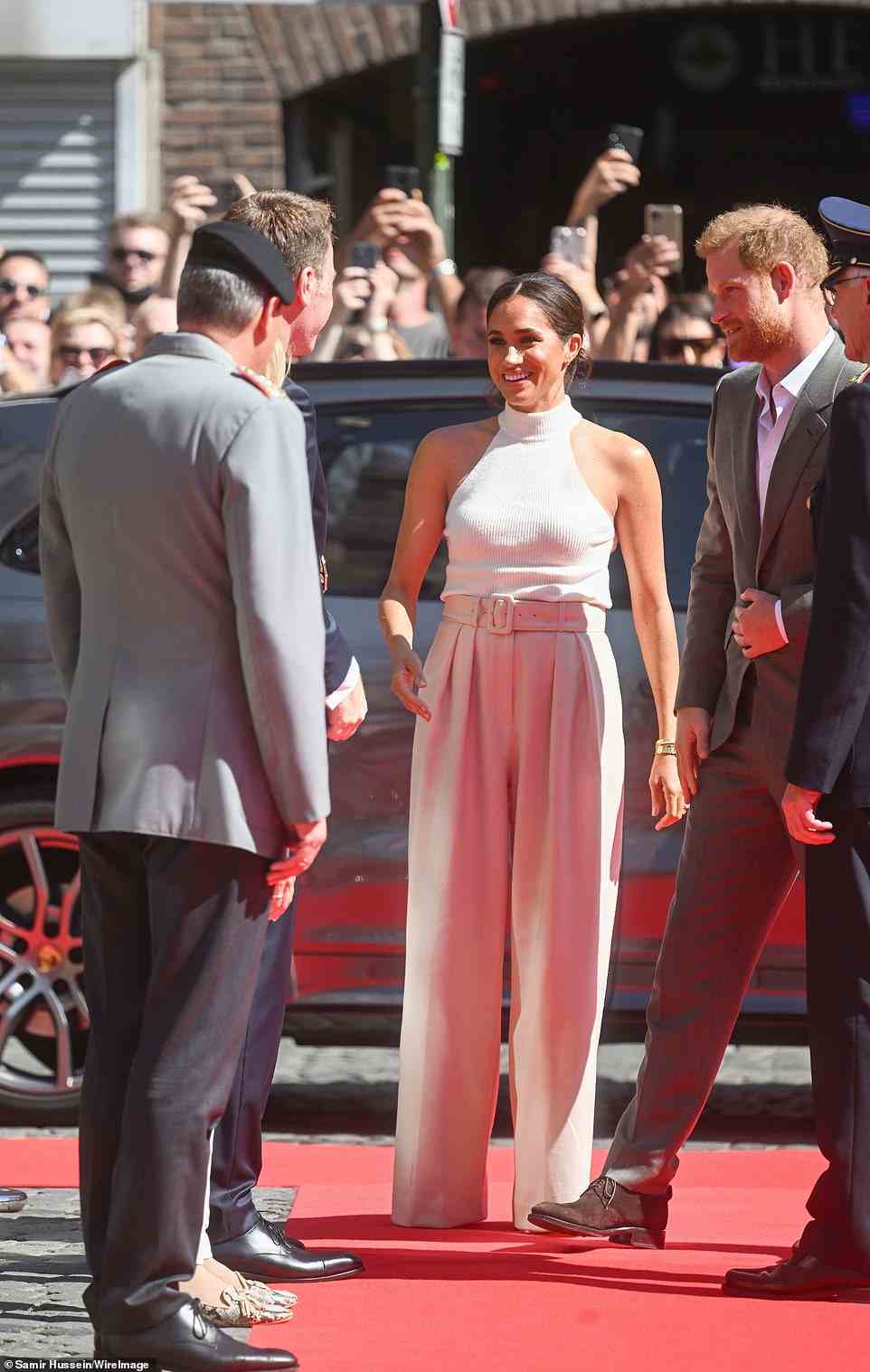 The Duchess of Sussex appeared to share a joke with the officials of the Invictus Games as she was pictured laughing with them on her arrival in Dusseldorf