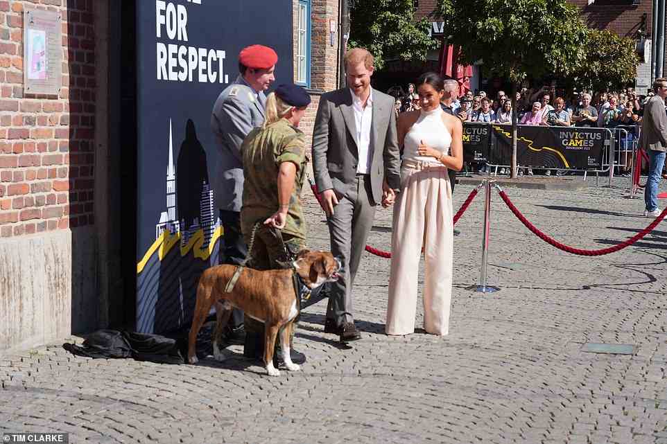 Duchess's best friend! Meghan appeared taken by a sweet service dog who was also on hand to greet the royal couple in Dusseldorf