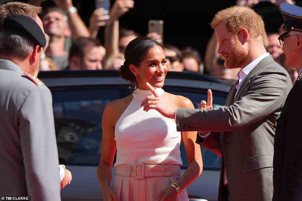 The look of love! Meghan flashed Harry a smile as he spoke to officials on arrival at the event, where they will also meet competitors for next year's event