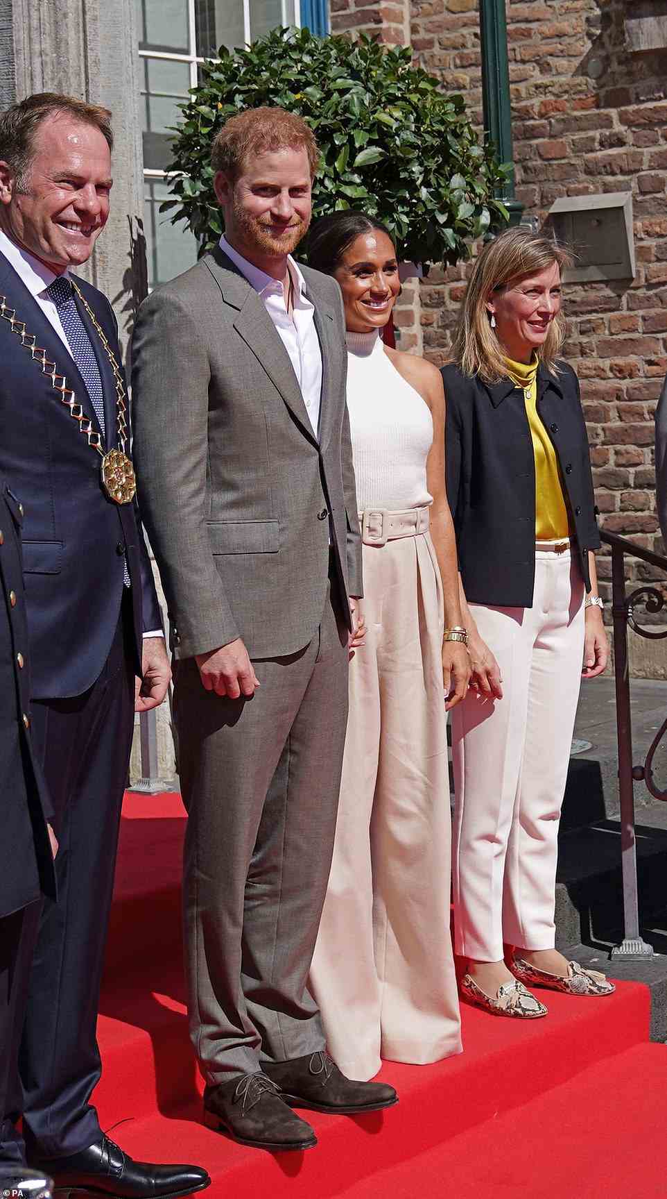 Harry and Meghan held hands as they posed for photos on the steps outside City Hall, looking delighted to be at the Invictus Games event
