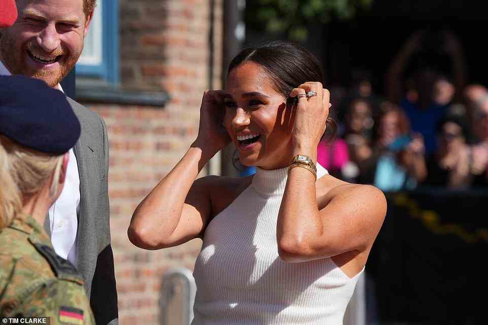 Meghan showed off her understated gold watch and bracelets as she tucked her hair behind her ears, as her locks were pulled back into a sleek low bun