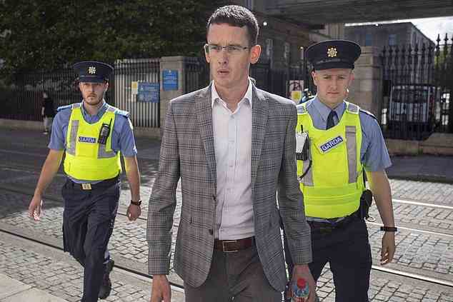 Teacher Enoch Burke (pictured on Monday being brought into the Bridewell Garda station in Garda custody) was arrested yesterday morning for breaching a court order not to teach at his Westmeath school, or be physically present there