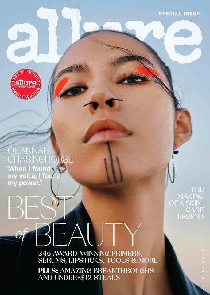 Model Quannah Chasinghorse auf dem Best of Beauty-Cover 2022 des Magazins Allure.  Auf dem Porträt ist ihr tätowiertes Kinn hochgehalten und Haarsträhnen wehen im Wind.  Sie trägt orangefarbene Pigmentspritzer auf ihren Augenlidern. 